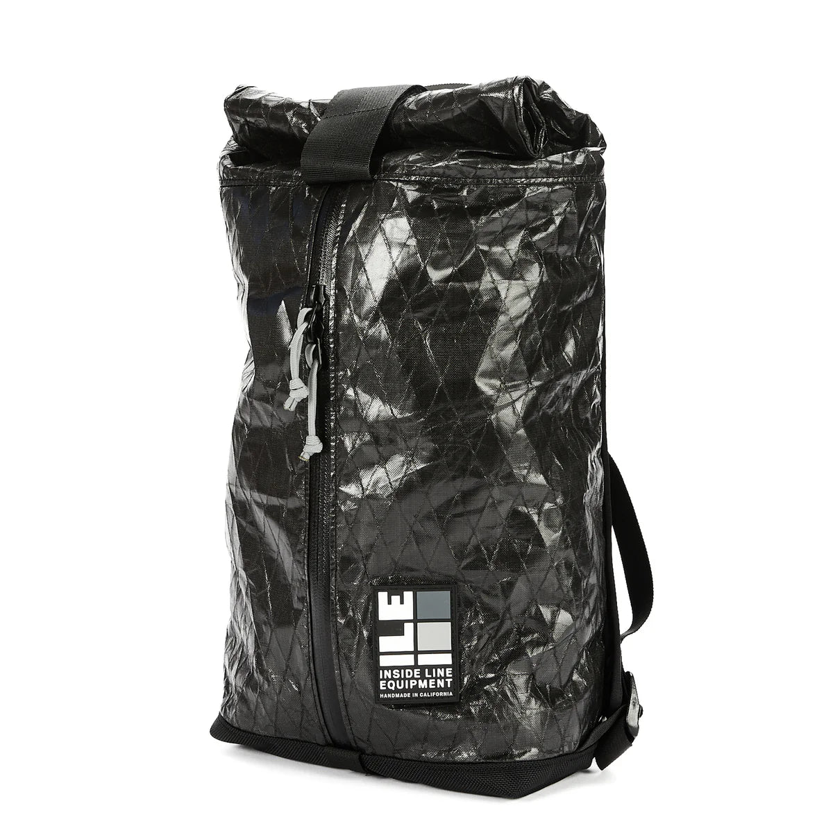 A black Apex Day Pack with a zippered main compartment and a roll-top Pleated interior pocket, featuring an adjustable shoulder strap and a padded back panel. The pack is shown against a white background.